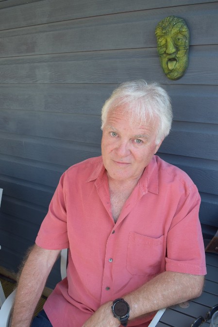 Paul Man with grey hair and raspberry coloured shirt